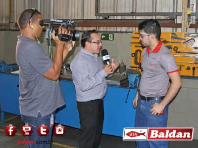 TVM entrevistando Vinícius Henrique Urbano dos Santos no seu ambiente de trabalho.